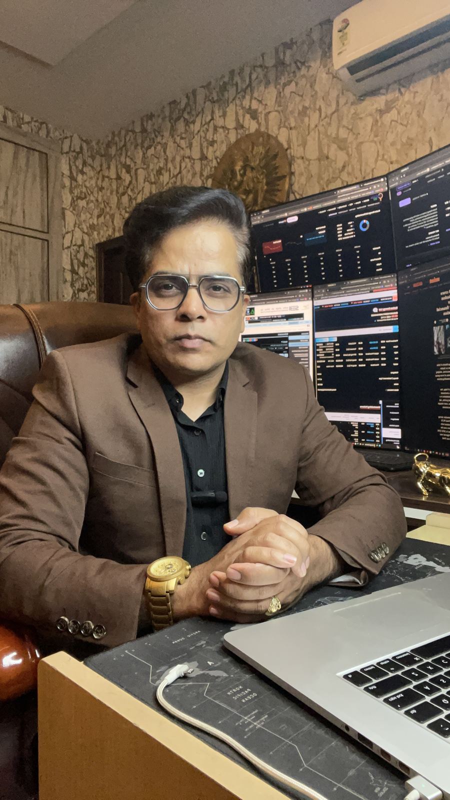 Sumit Bhardwaj, founder of SB Stocks, in a brown blazer at his trading desk